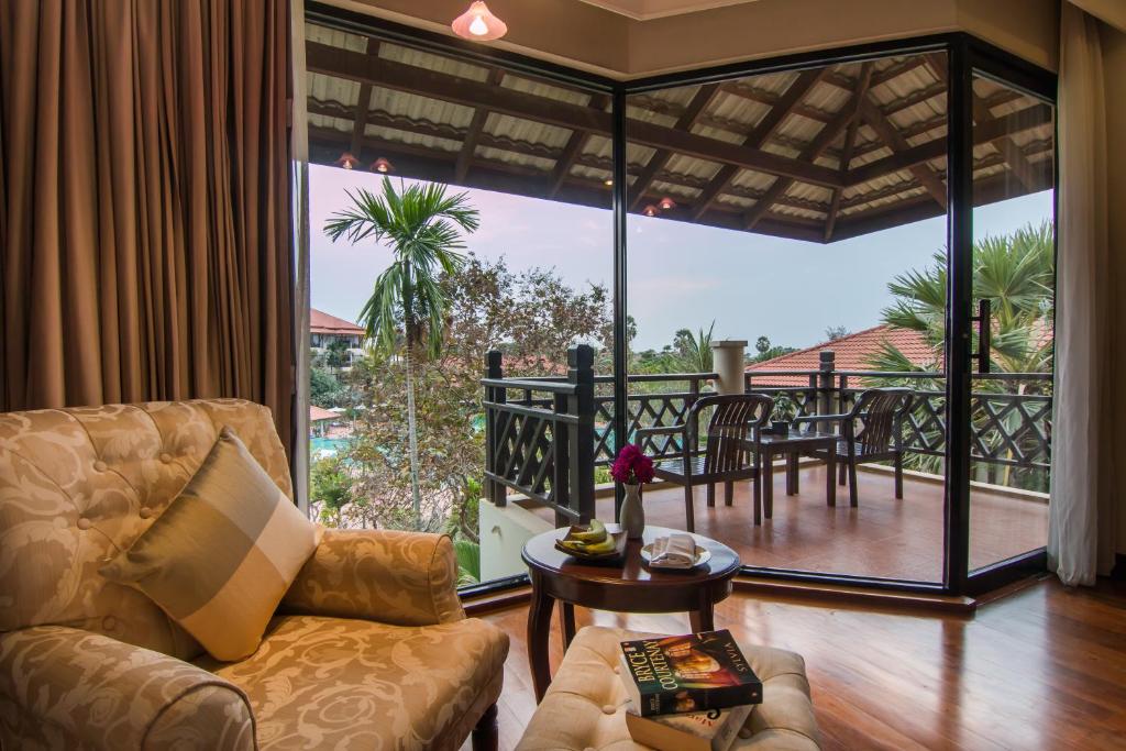 a living room with a couch and a table and a balcony at Palace Residence & Villa Siem Reap in Siem Reap
