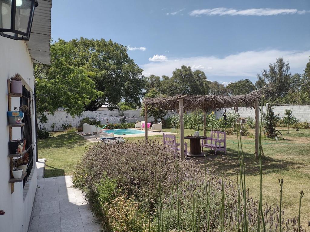 un patio trasero con piscina y cenador en ESPACIO CANELA en Ramallo