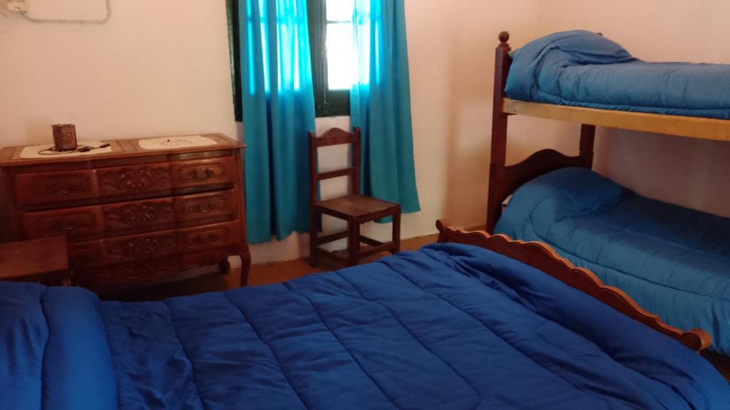 um quarto com uma cama, uma cómoda e uma secretária em La Casa De La Gruta em Mina Clavero