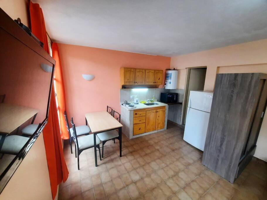a small kitchen with a table and a refrigerator at Departamento en Mendoza Capitál in Mendoza