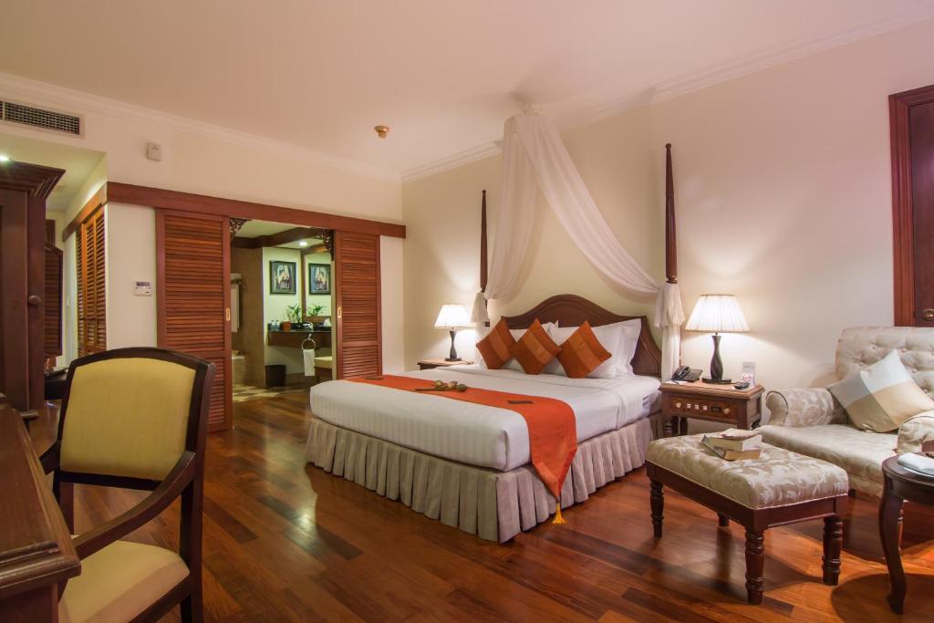 a hotel room with a bed and a couch at Palace Residence & Villa Siem Reap in Siem Reap