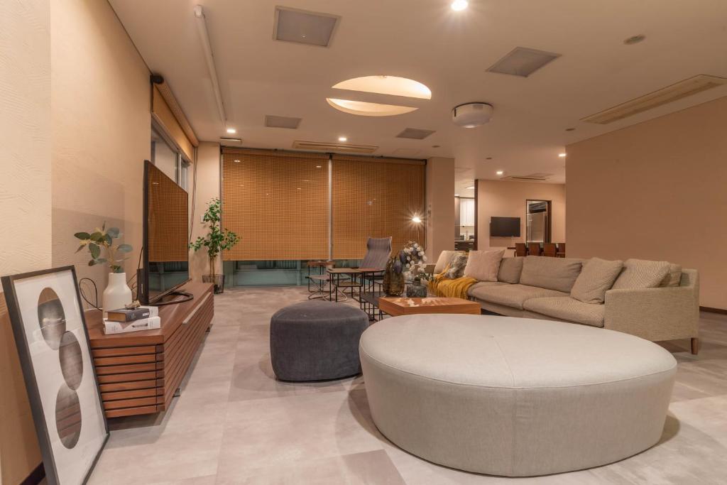 uma sala de estar com um sofá e uma mesa em Bijou Suites AI PREMIUM em Osaka