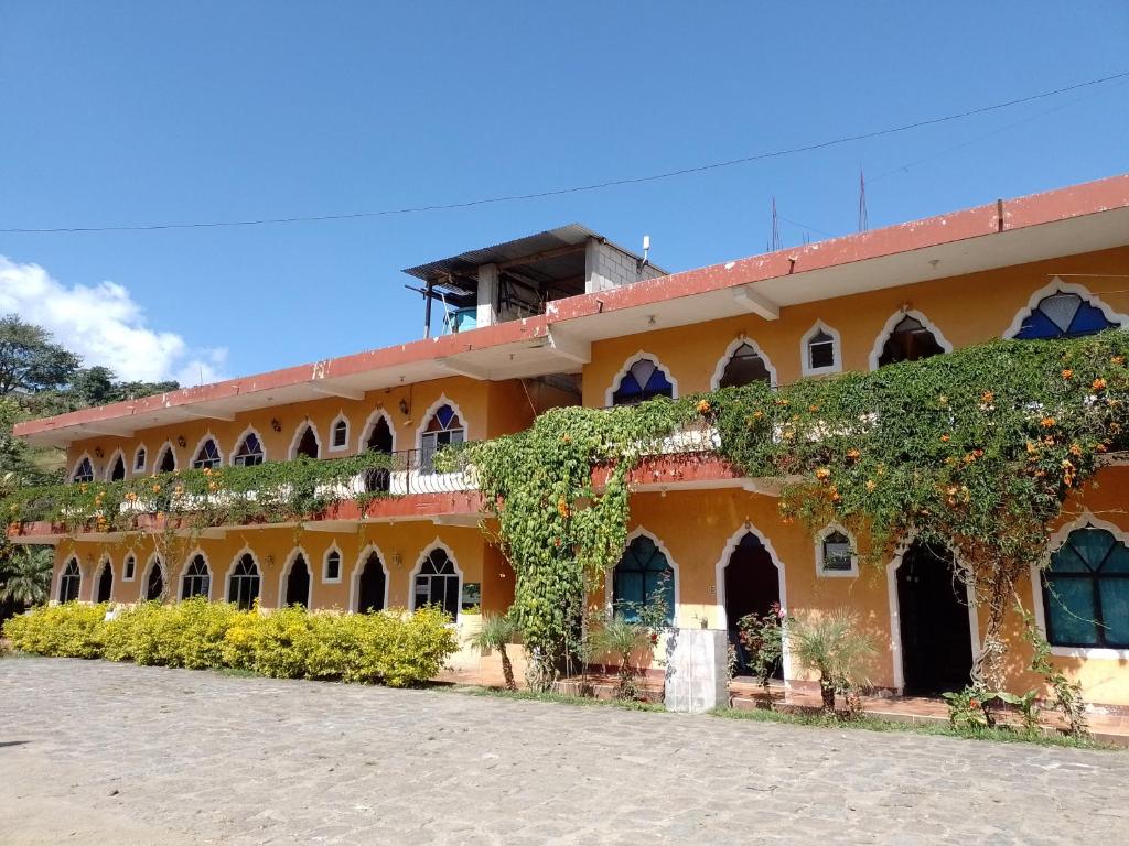 pomarańczowy budynek z bluszczem na boku w obiekcie Hotel y Restaurante Tzutujil w mieście San Lucas Tolimán