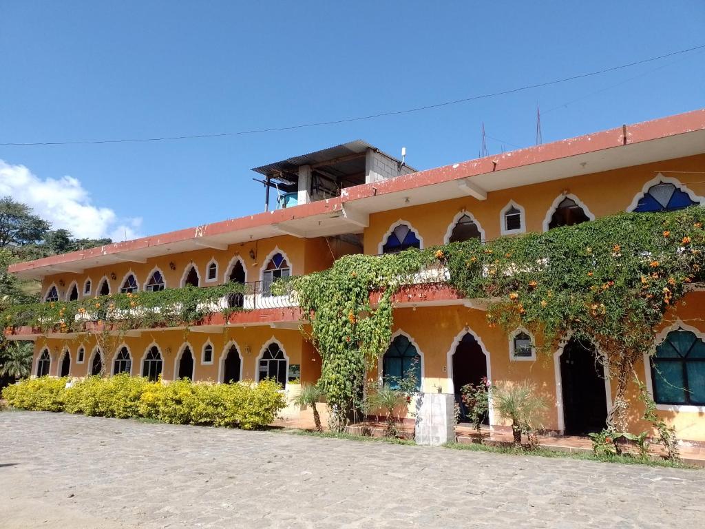 un edificio anaranjado con hiedra a un lado. en Hotel y Restaurante Tzutujil, en San Lucas Tolimán