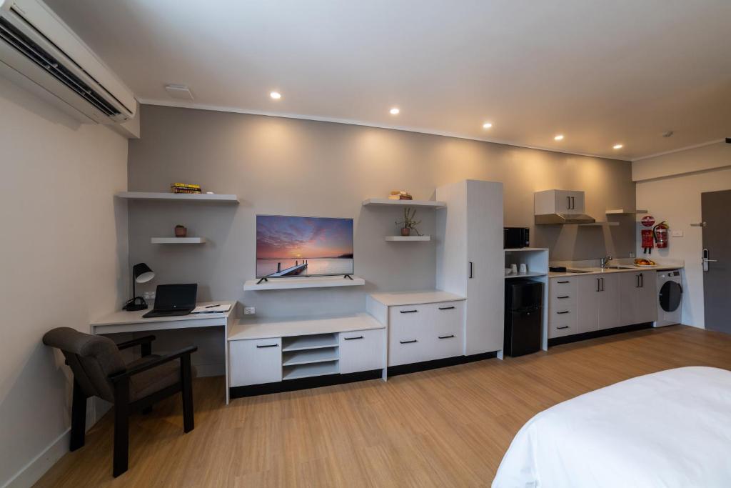 1 dormitorio con 1 cama y escritorio con ordenador en Toorak Central, en Suva