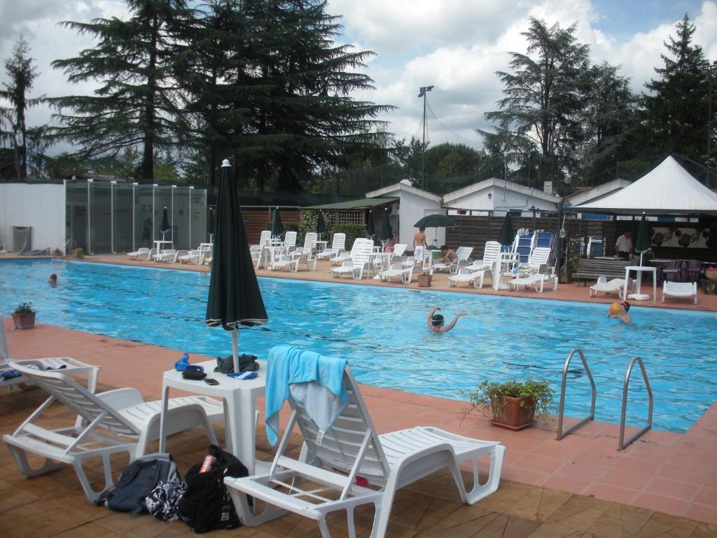 una piscina con sedie, ombrelloni e persone che nuotano di Nostra Signora Del Lago a Ronciglione