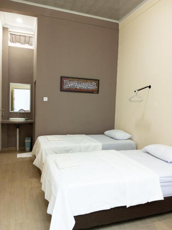 Postel nebo postele na pokoji v ubytování Bu Sepuh GuestHouse