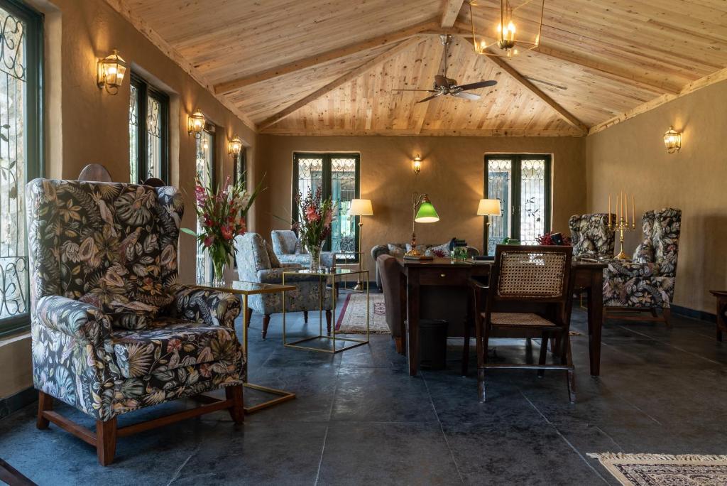 un soggiorno con tavolo e sedie di Aalia Jungle Retreat and Spa, Bandarjudh, Haridwar - Araiya Anthology a Dehradun