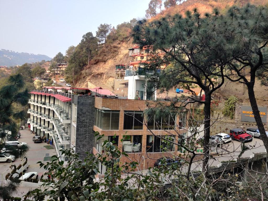 un edificio al lado de una montaña en Wood Creek Resort & Spa Kasauli en Kasauli
