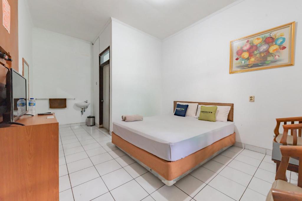 Un pat sau paturi într-o cameră la Urbanview Hotel Pondok Kurnia Cijagra Bandung