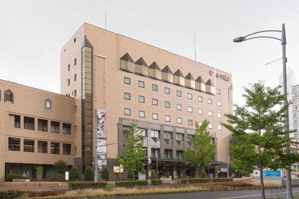 a large building on a city street with a street light at Hotel Rubura Ohzan in Nagoya