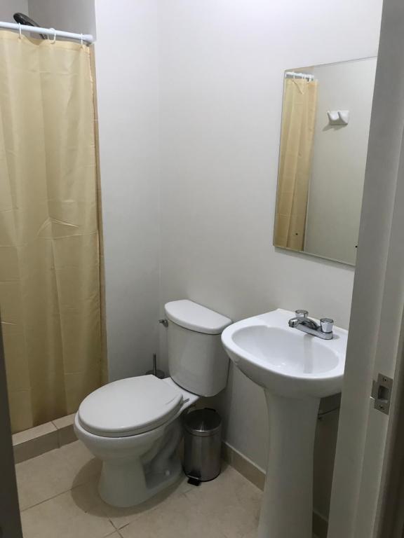 y baño con aseo y lavamanos. en Departamento de estreno en 1er piso en Condominio, en Piura