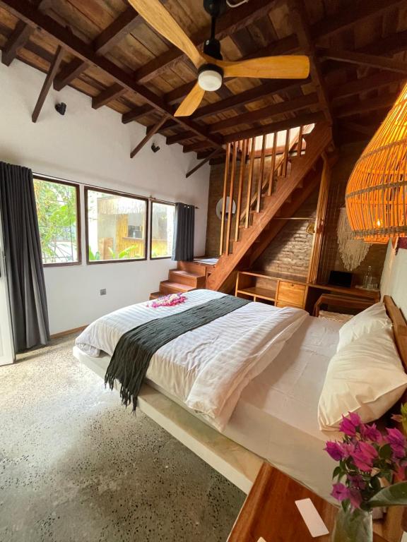 a bedroom with a large bed with a wooden ceiling at Tipsea Turtle Gili Air in Gili Islands