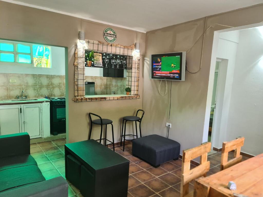 福爾摩沙的住宿－alquiler temporal DIARIO DE IRIGOYEN，厨房设有带凳子的酒吧和一台电视机。