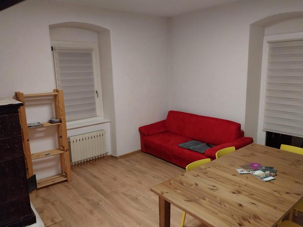 sala de estar con sofá rojo y mesa en Appartamento vista Parco Adamello Brenta, en Ossana