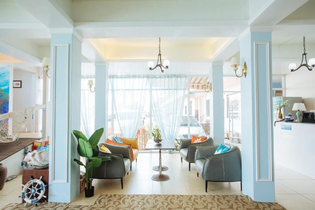 a living room with chairs and a table at Seaward Sea view double room with balcony in Koror