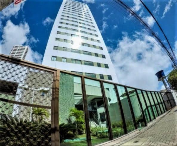 un edificio alto con una valla delante en Apto moderno e bem localizado, en Recife