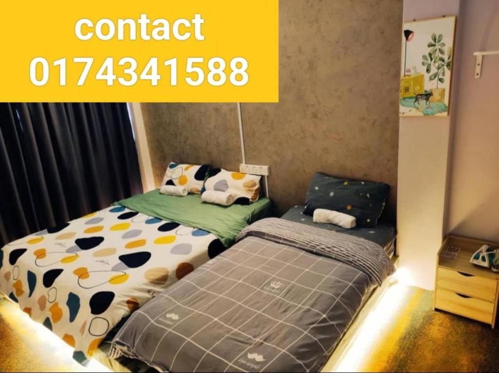 two beds in a room with a yellow sign that reads contact at LUNAS DIY HOMESTAY in Lunas