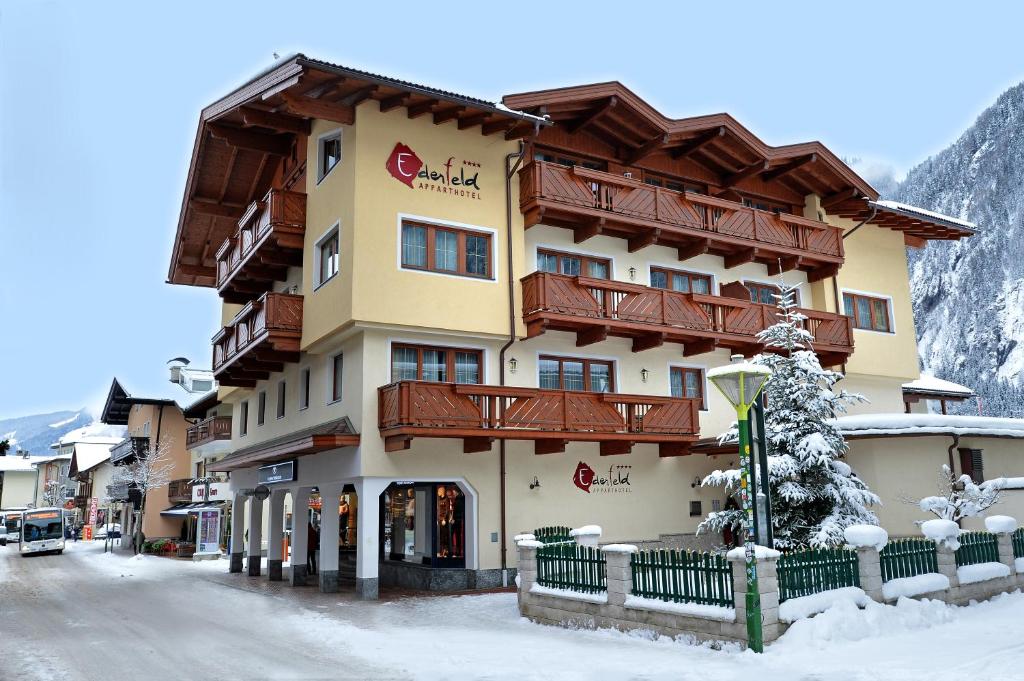 un hotel en las montañas con nieve en el suelo en Apparthotel Ederfeld, en Mayrhofen