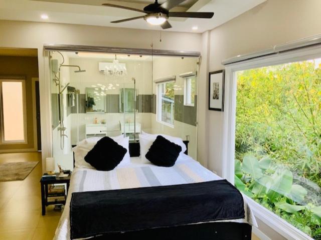 ein Schlafzimmer mit einem großen Bett und einem großen Fenster in der Unterkunft Casa de Simone in Bagac