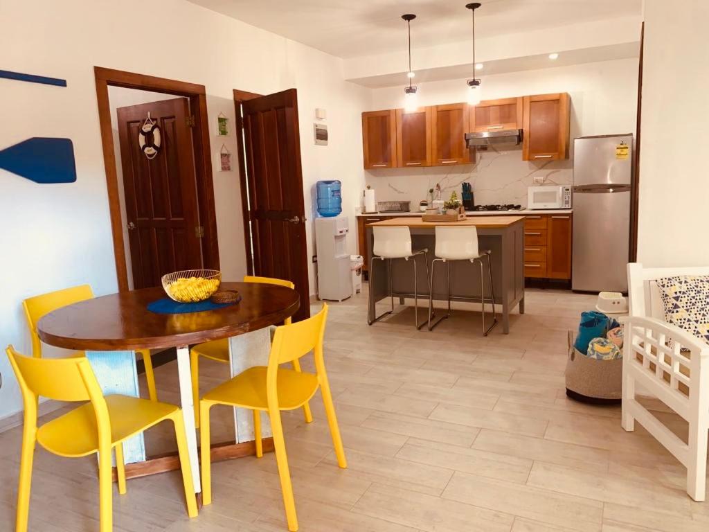uma cozinha com uma mesa e cadeiras amarelas num quarto em Lovely Beachfront 2 bedrooms condo with 2 pools em Las Terrenas