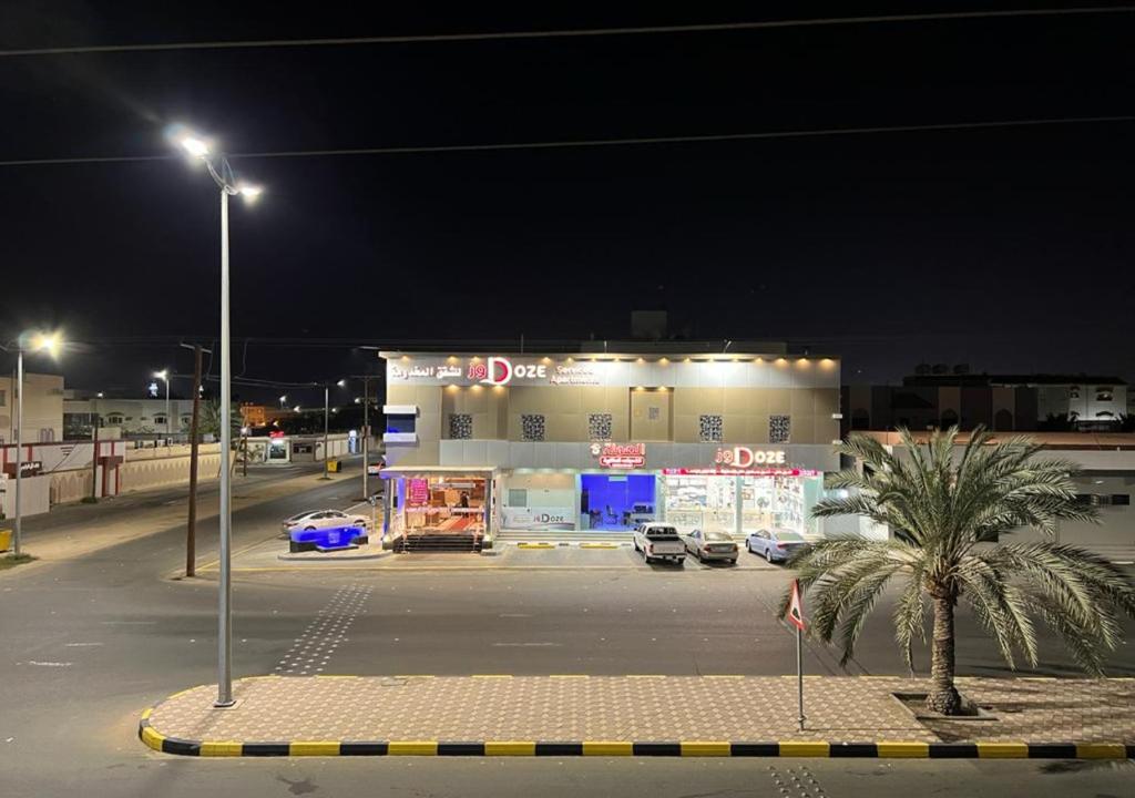 a parking lot in front of a garage at night at دوز للشقق المخدومة in Najran