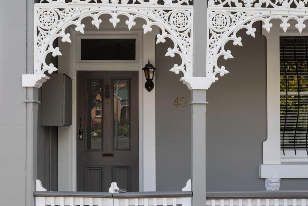 a front door of a white house with an archway at Two Worlds Townhouse in Launceston