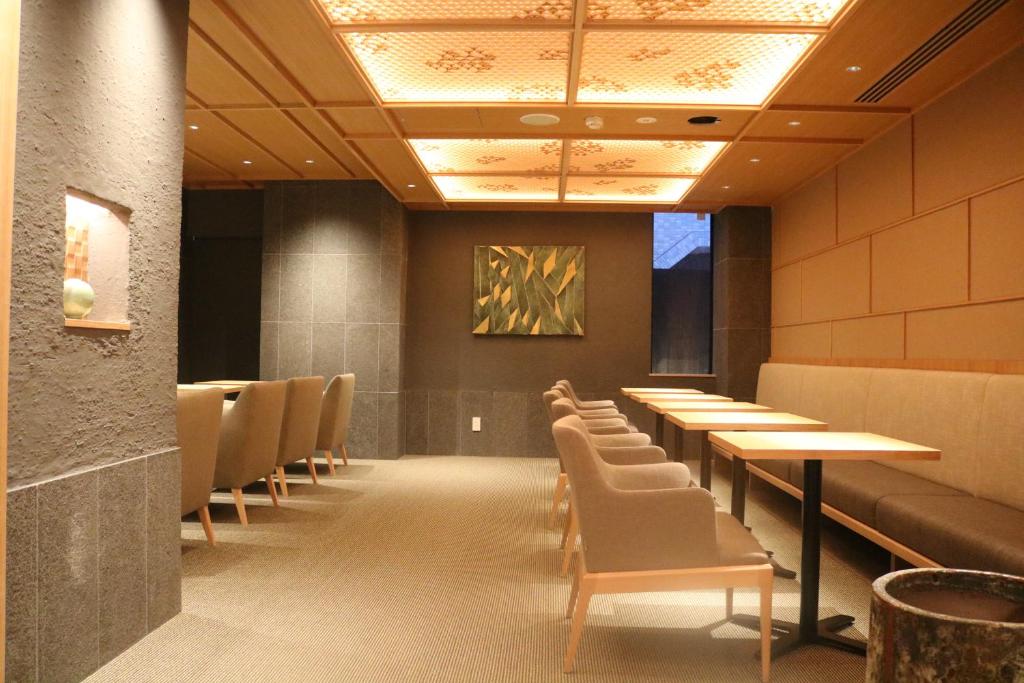 a dining room with tables and chairs and a painting at THE GENERAL KYOTO Bukkouji Shinmachi in Kyoto