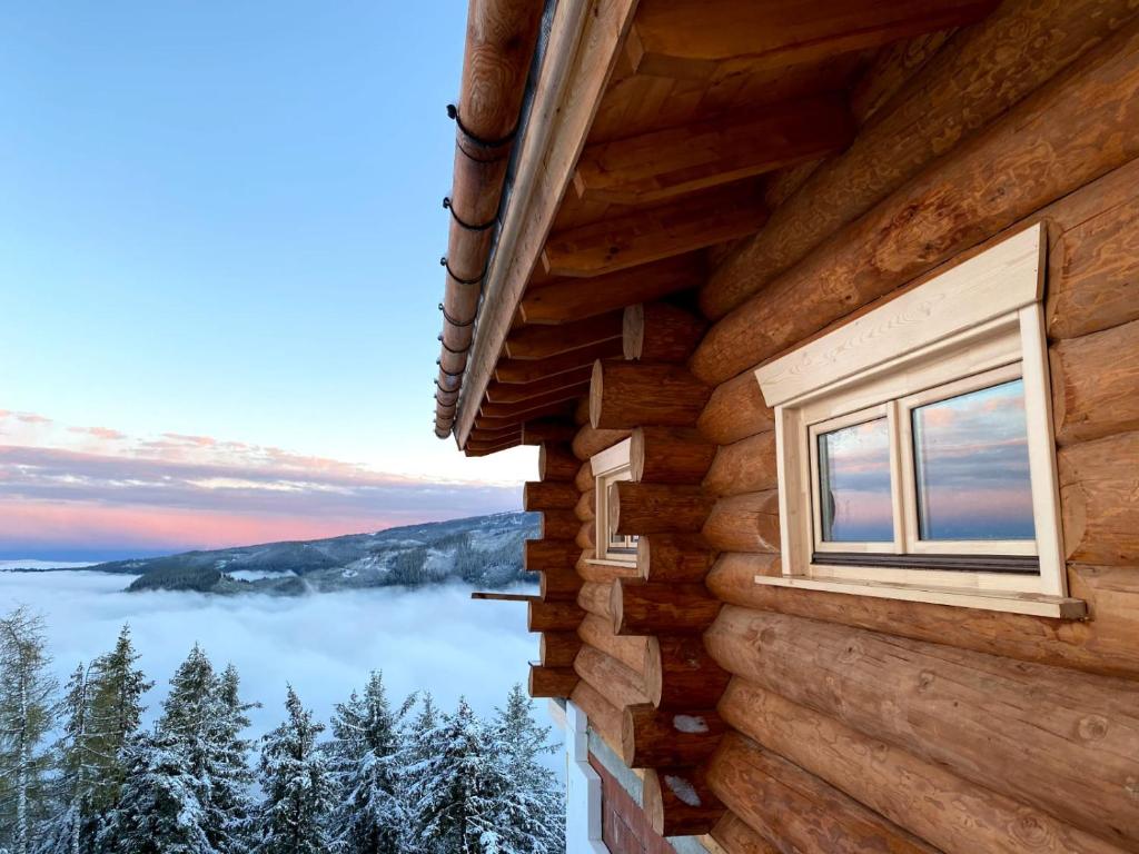 una ventana de una cabaña de madera con vistas al lago en KlippitzStar en Bad Sankt Leonhard im Lavanttal
