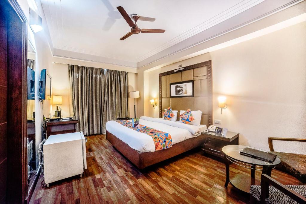 um quarto de hotel com uma cama e uma ventoinha de tecto em FabHotel BMK Grand em Nova Deli