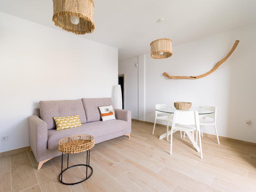 uma sala de estar com um sofá e uma mesa em Arena y Calma Jandia con aire acondicionado em Morro del Jable