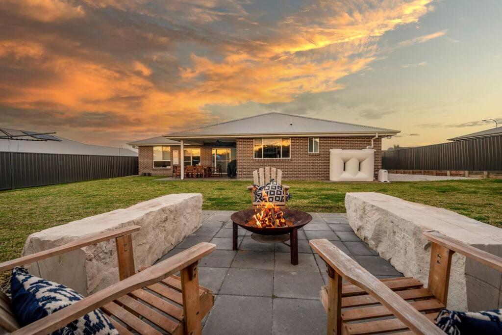 a patio with two benches and a fire pit at 'Devan House' Family Retreat with Games Room in Mudgee