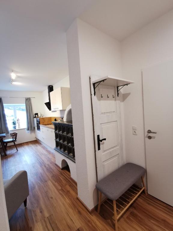 a living room with a door and a kitchen at Apartments HAUS SCHÖN - Preise inclusive Pitztal Sommer Card in Jerzens