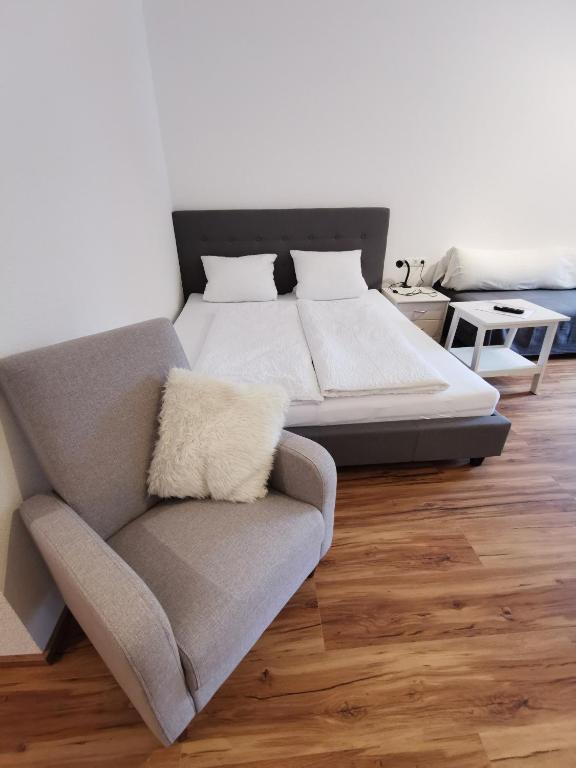 a bedroom with a bed and a couch and a chair at Apartments HAUS SCHÖN - Preise inclusive Pitztal Sommer Card in Jerzens