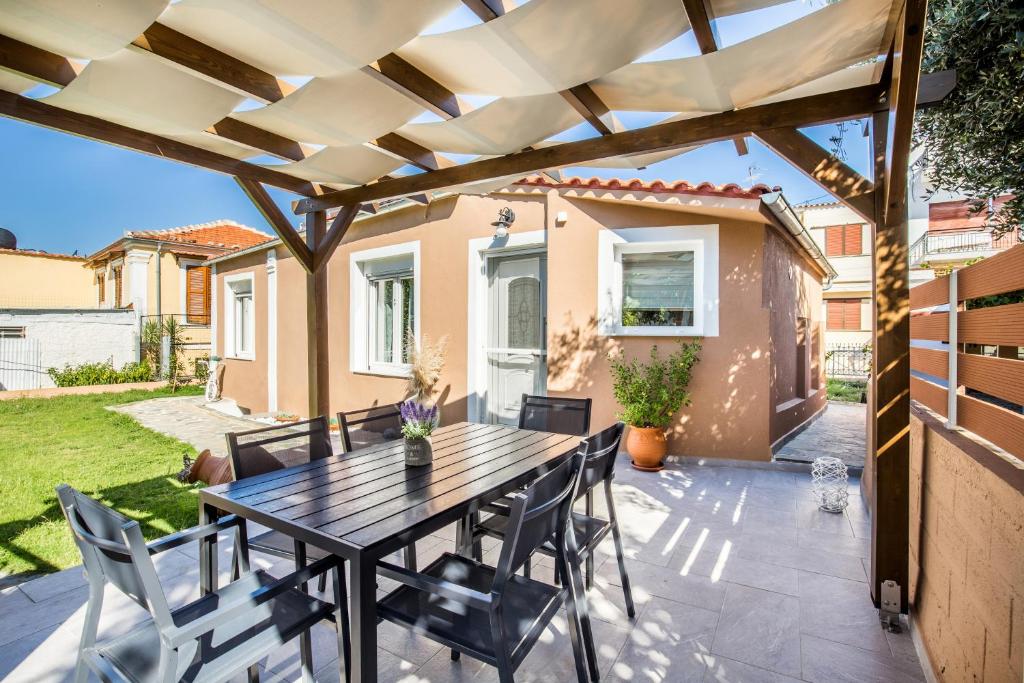 a patio with a wooden table and chairs at Villa Pines in Limenaria