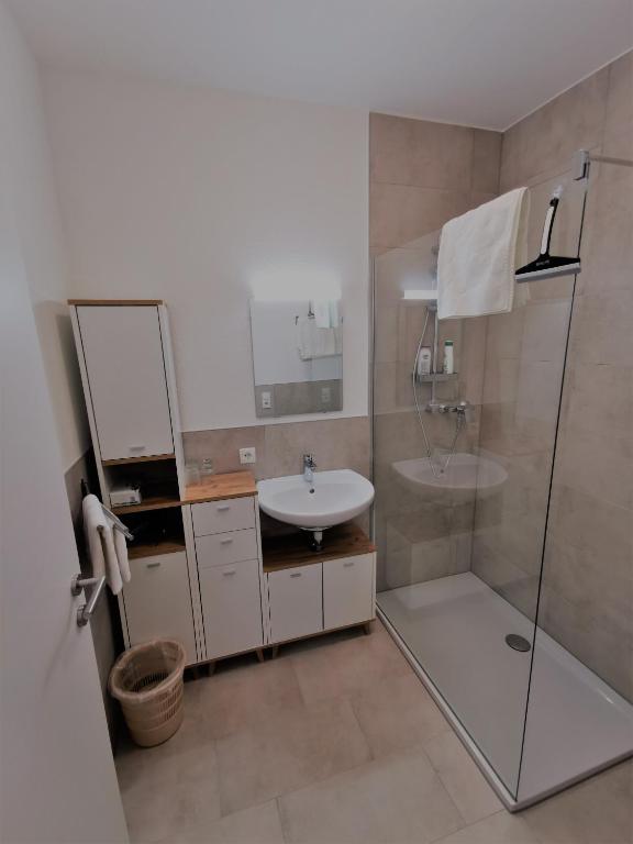 a bathroom with a sink and a shower at Apartments HAUS SCHÖN - Preise inclusive Pitztal Sommer Card in Jerzens