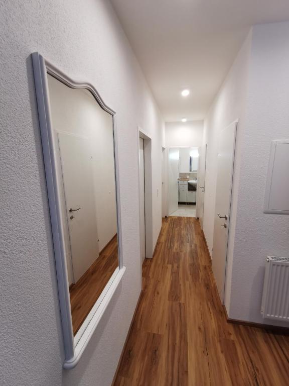 an empty hallway with a mirror on the wall at Apartments HAUS SCHÖN - Preise inclusive Pitztal Sommer Card in Jerzens