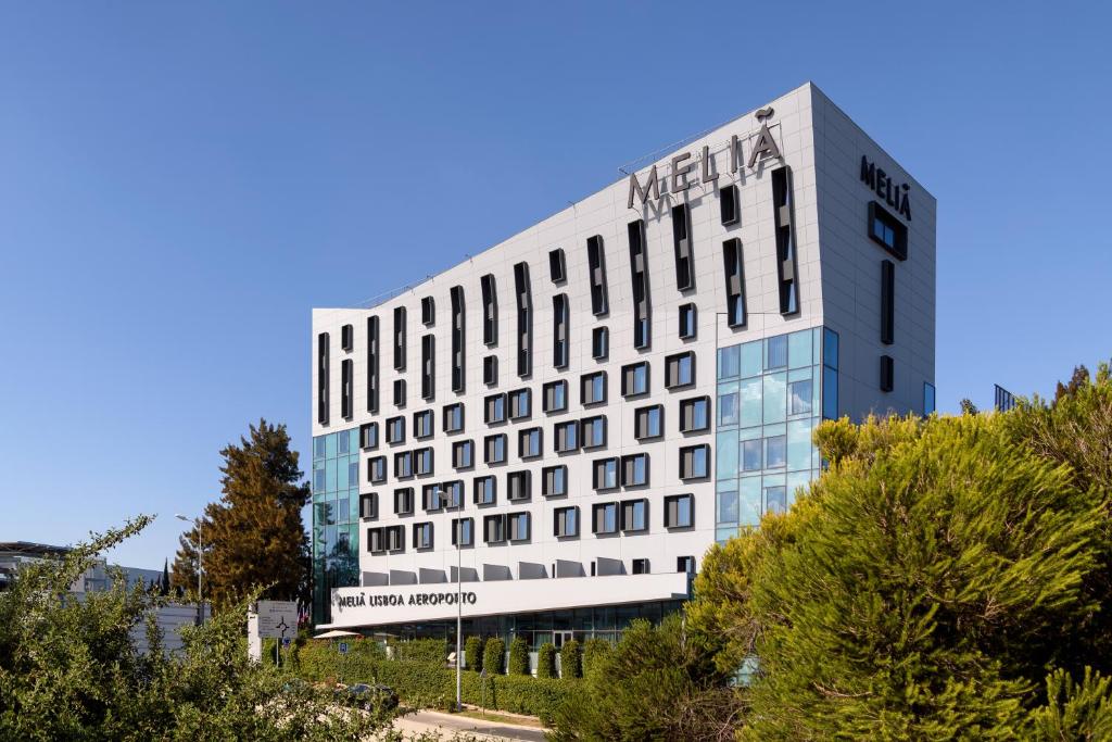 um edifício branco alto com muitas janelas em Meliá Lisboa Aeroporto em Lisboa