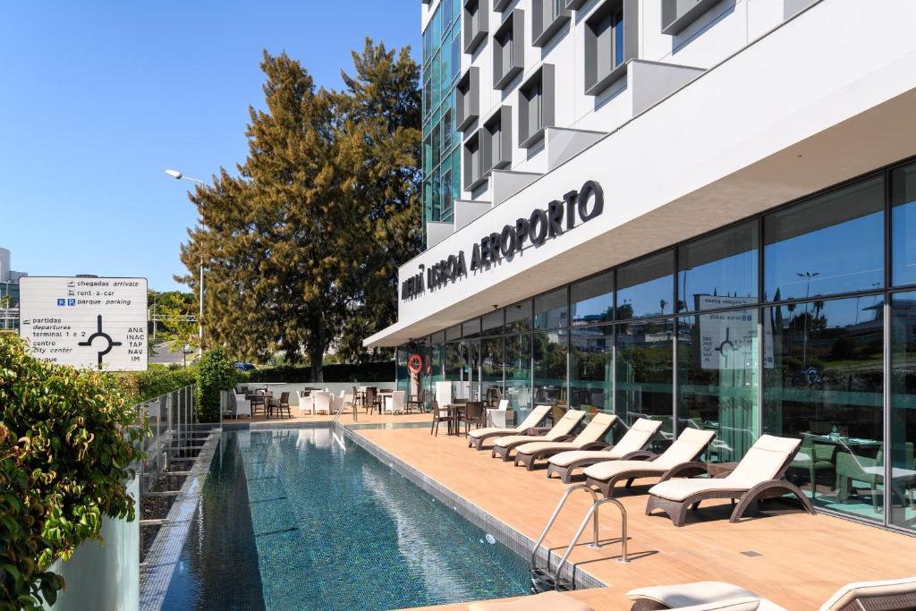 un hotel con piscina frente a un edificio en Meliá Lisboa Aeroporto en Lisboa