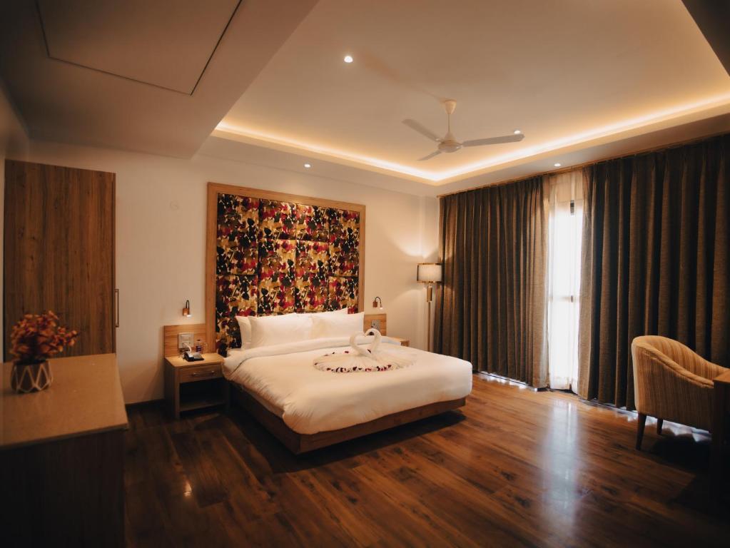 a bedroom with a bed and a large painting on the wall at Clarks Inn Express, Dehradun in Dehradun