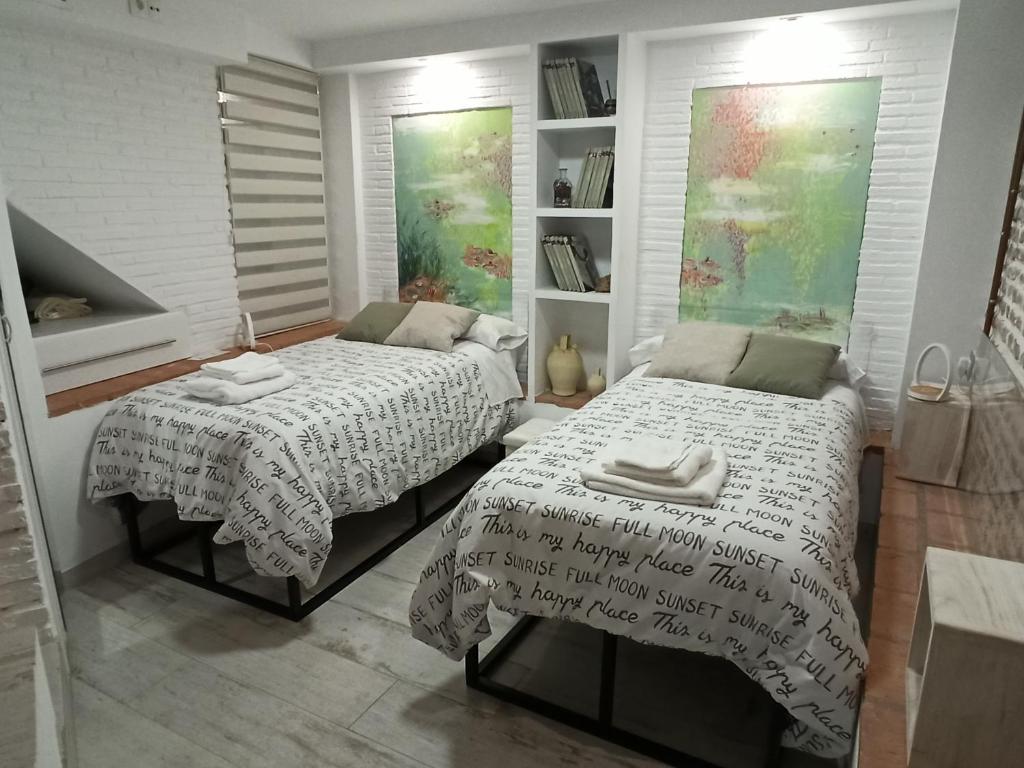 a bedroom with two beds and a book shelf at Martina´s home in Córdoba
