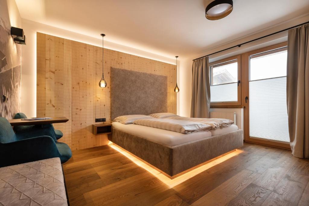 a bedroom with a bed and a table and a couch at Hotel Garni Landhaus Platzer in Zell am Ziller