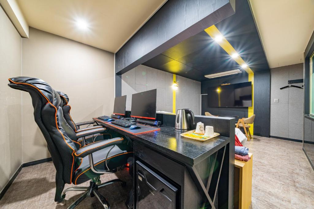 ein Büro mit einem Schreibtisch mit einem Computer und Stühlen in der Unterkunft Boutique Hotel XYM in Suwon