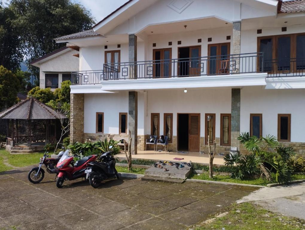 duas motos estacionadas em frente a uma casa em Villa bhifa Puncak em Bogor