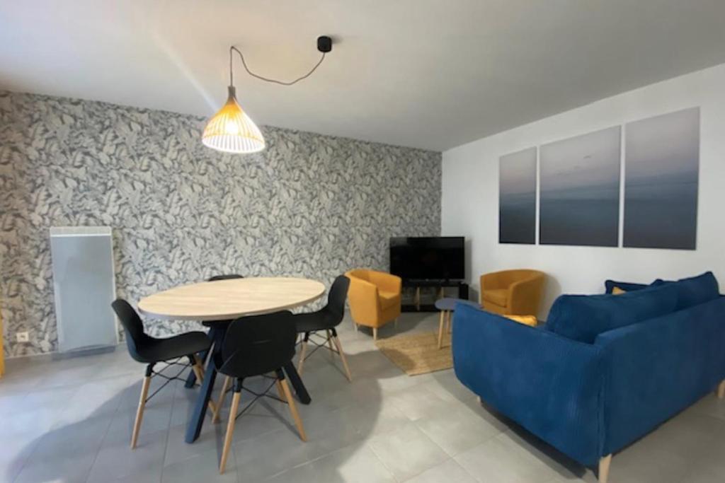 a living room with a blue couch and a table at Cosy apartment with balcony in the heart of Caen in Caen