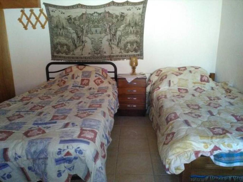 una camera da letto con due letti e un comò di TRADITIONAL HOUSE a Monemvasía
