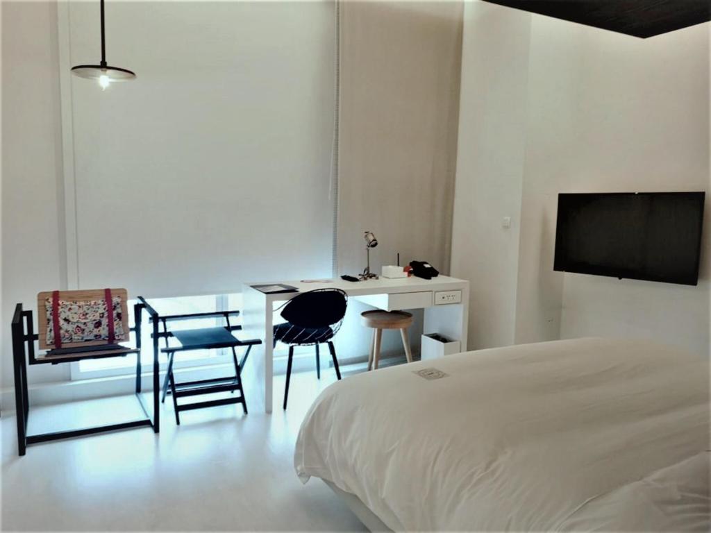 a bedroom with a bed and a table and chairs at The Place Tainan in Tainan