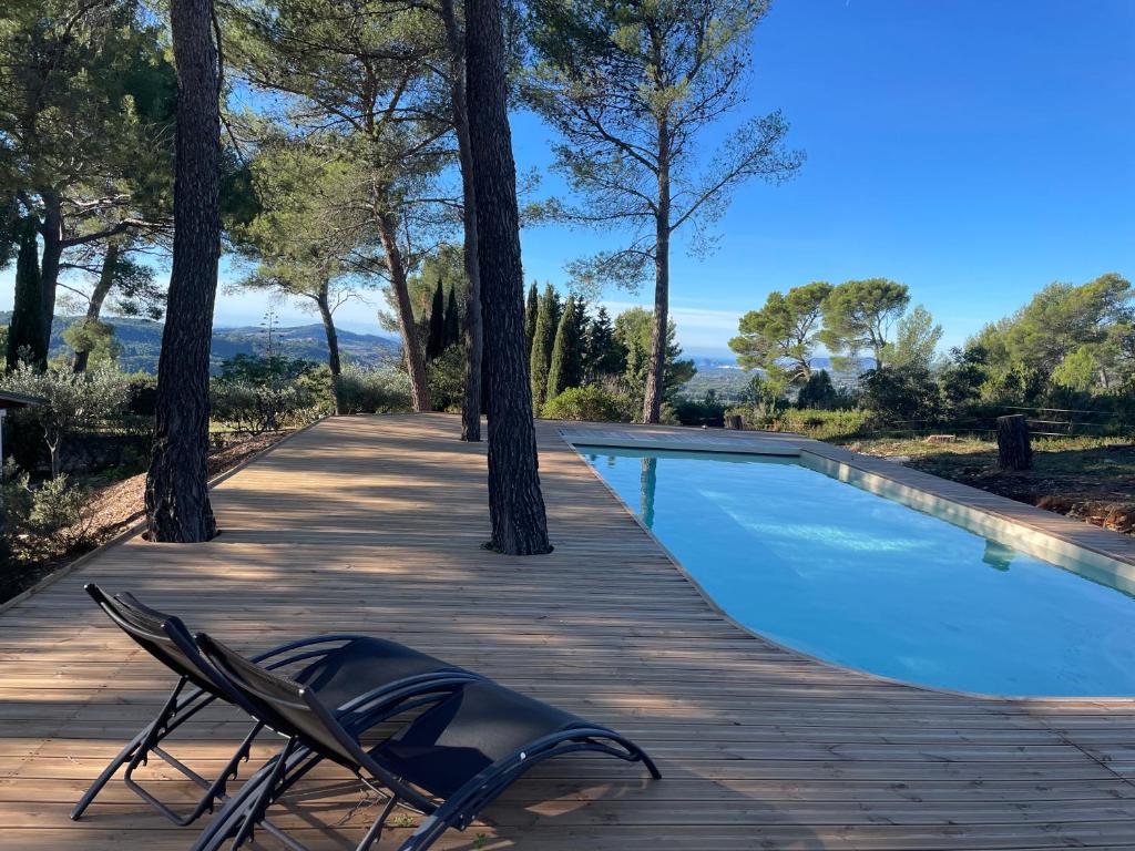 a deck with a chair and a swimming pool at Le Cigalon in Le Beausset