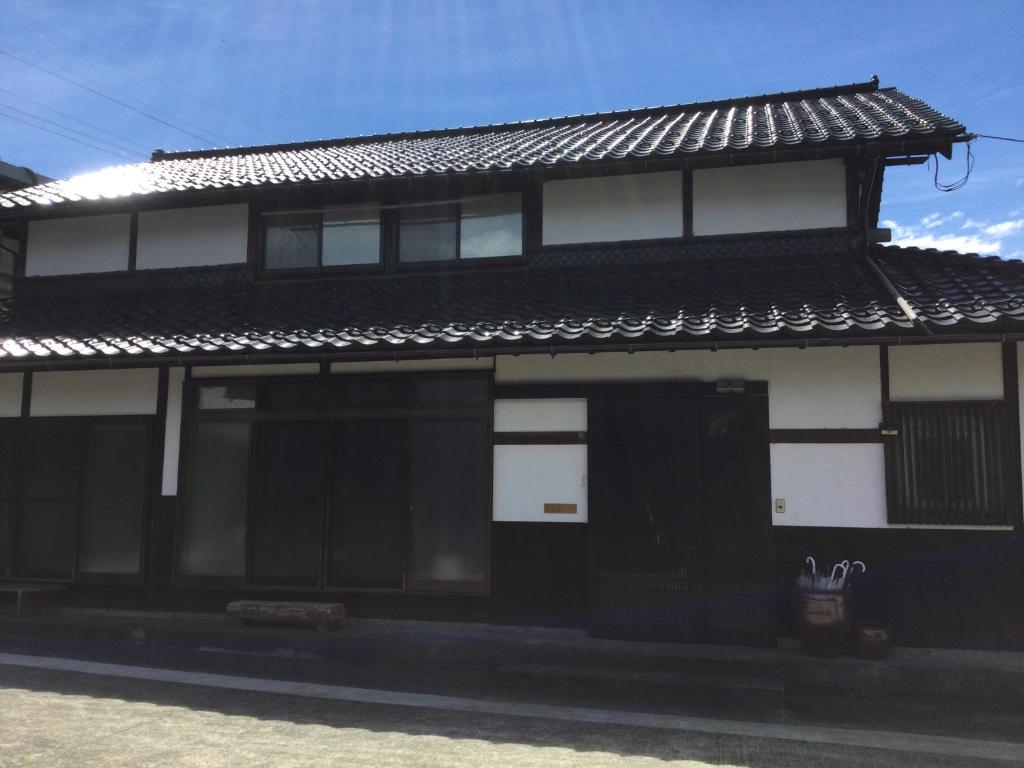 ein Schwarz-Weiß-Gebäude mit einer schwarzen Tür in der Unterkunft 古民家柚子季 in Tonami