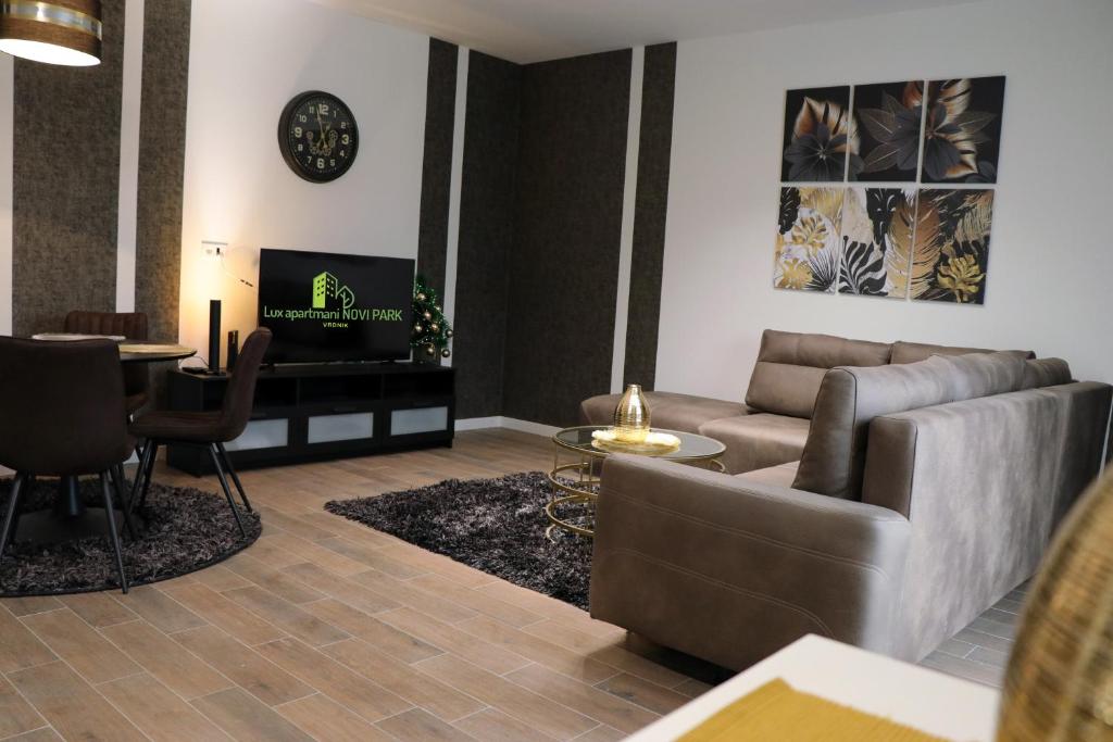 salon z kanapą i telewizorem w obiekcie Lux Apartmani Novi Park w mieście Vrdnik